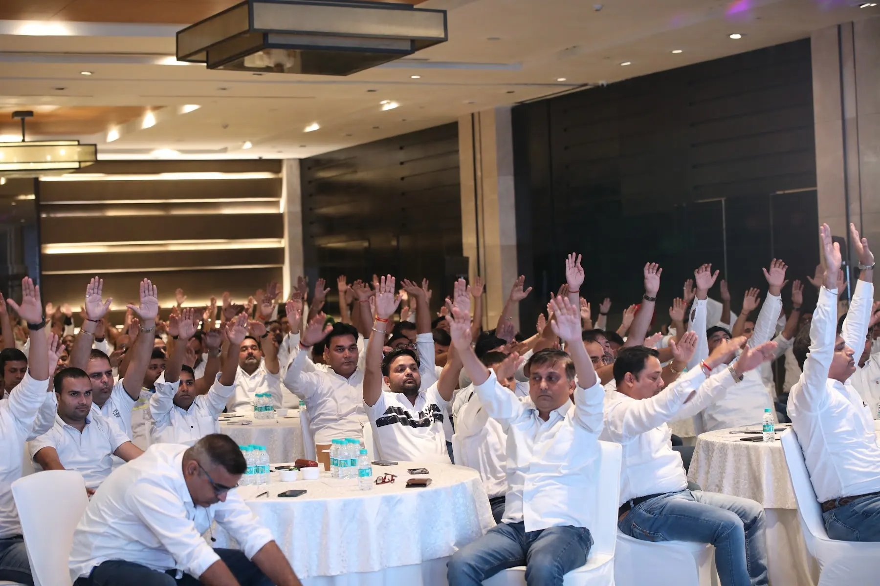 Corporate audience raising their hands